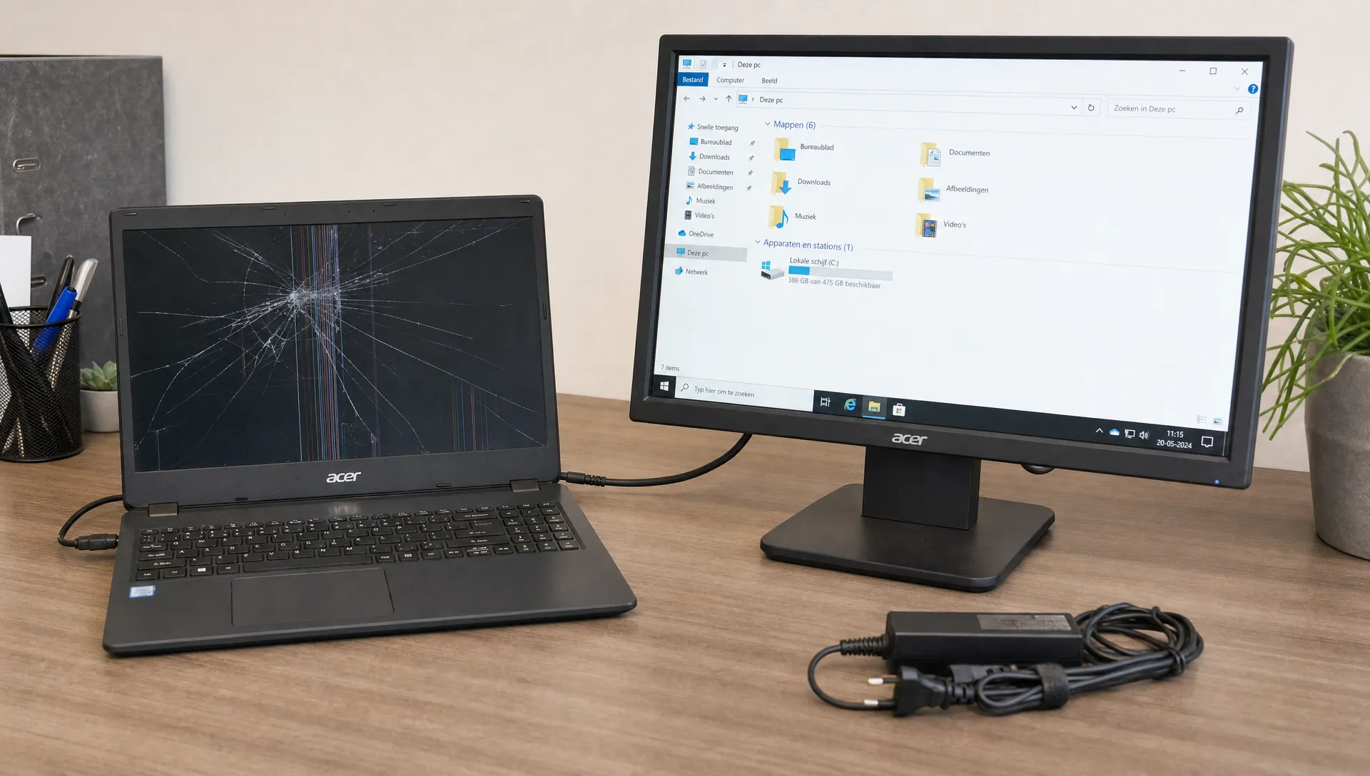 Een Acer laptop op een bureau met een gebarsten scherm, aangesloten op een externe monitor zodat bestanden veilig kunnen worden bekeken. De laptop staat stabiel open, zonder druk op het beschadigde scherm, met een oplader en kabel netjes naast het apparaat.